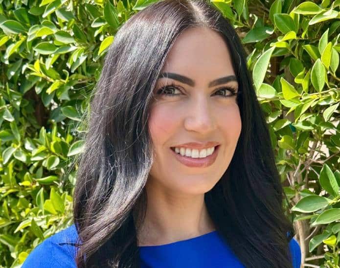 a woman wearing a blue shirt and smiling at the camera